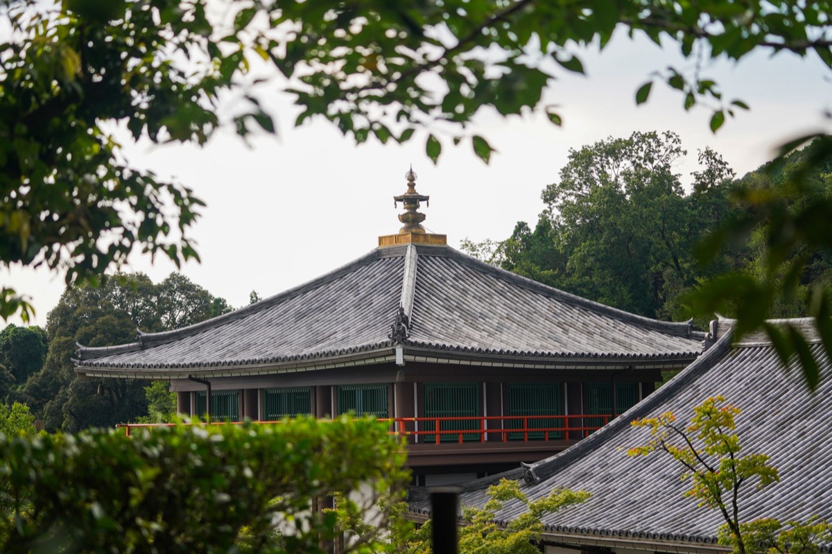 Traditionelle Shinto-Statue neben modernem Bürogebäude