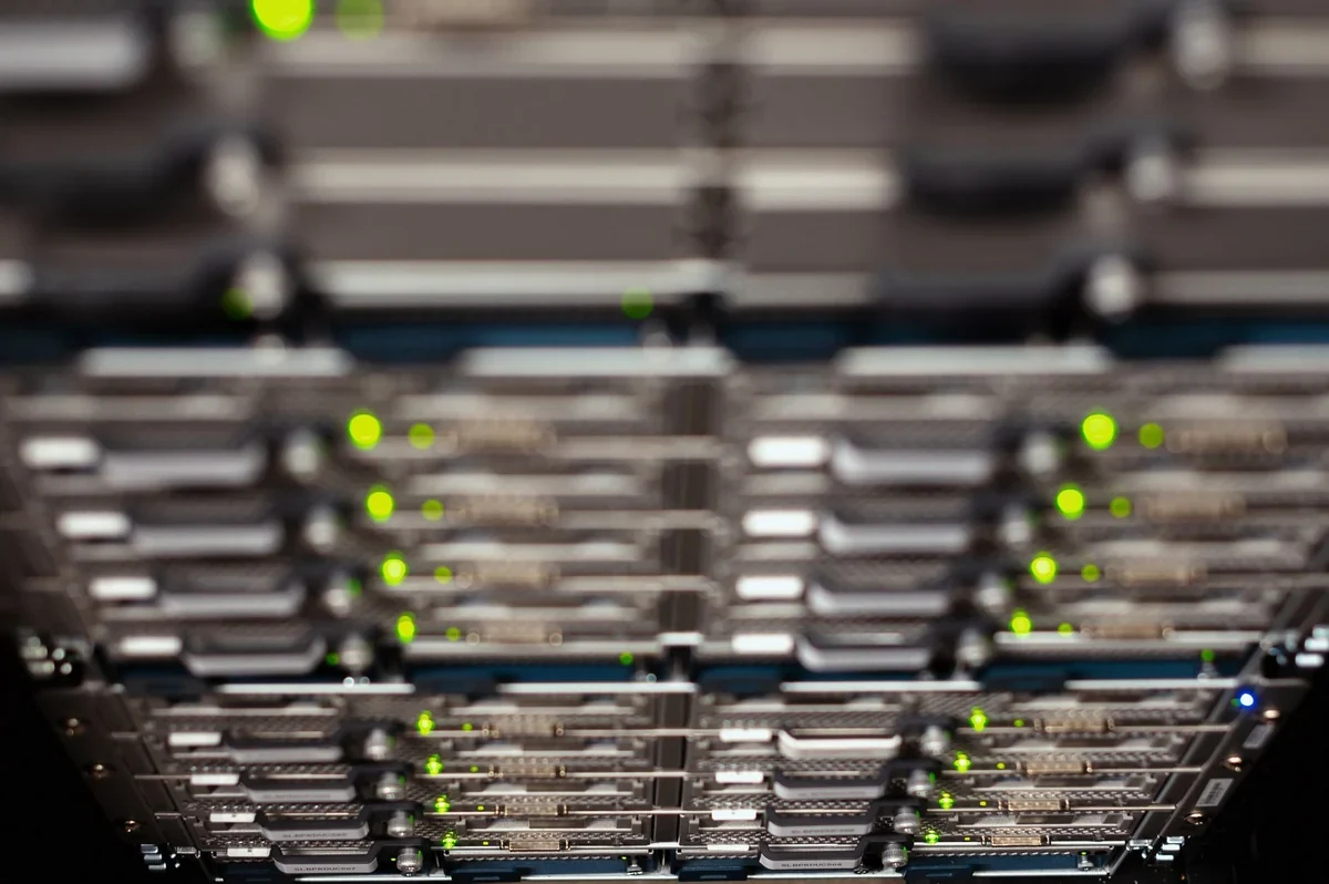 データセンター内の点滅するライトが付いた黒いコンピューターサーバーラックの列