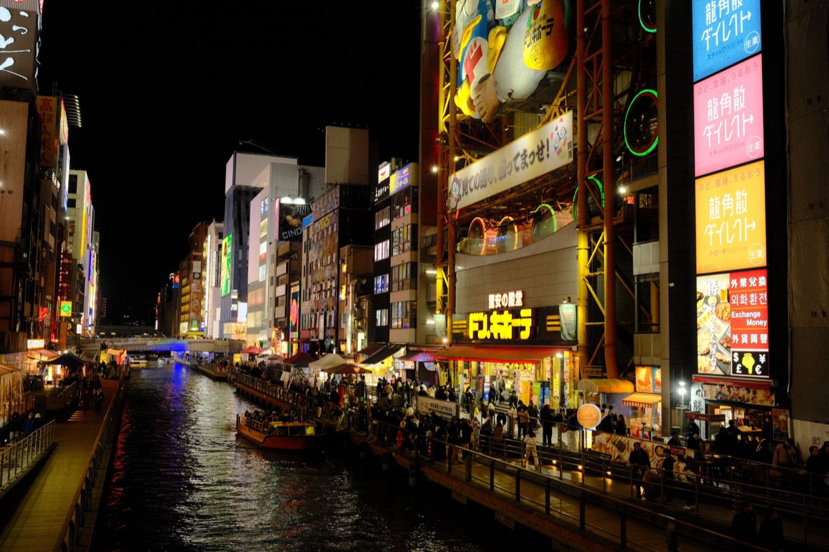 Dotonbori food stalls with neon signs and street vendors
